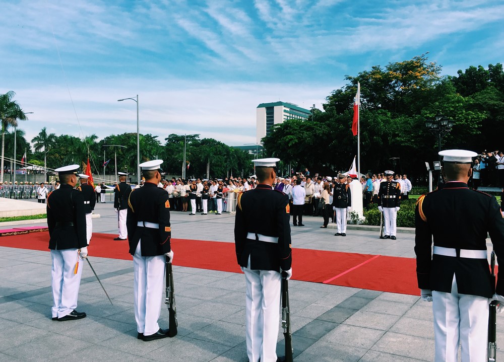 row of soldiers stand next to red carpet