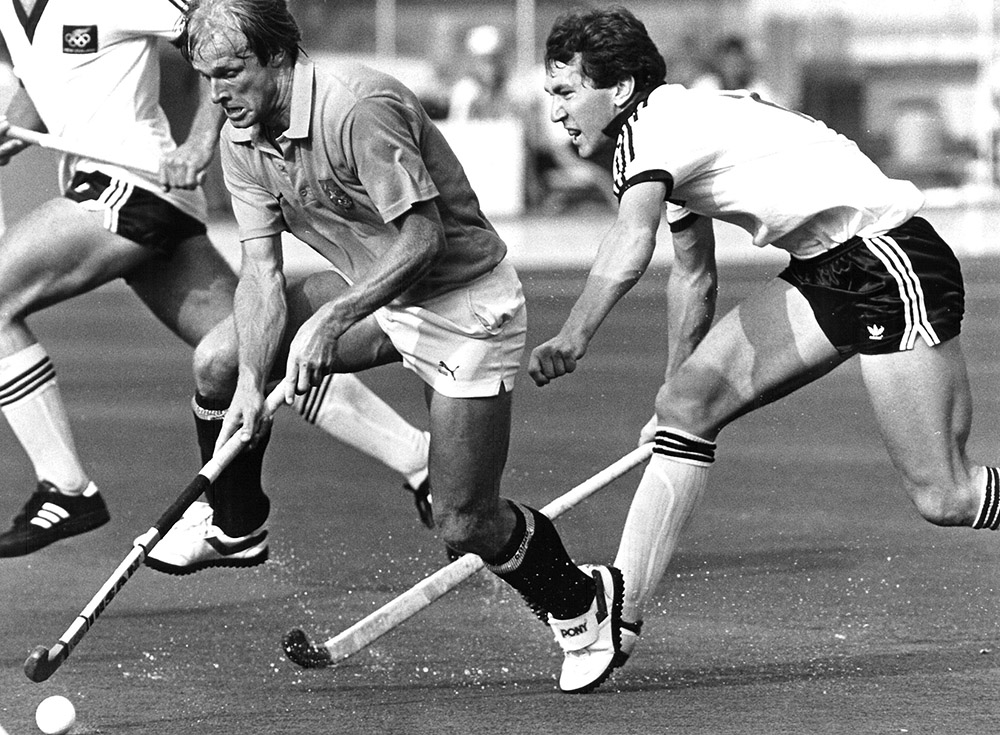 Peter Miskimmin looking to relieve an opposition hockey player of the ball