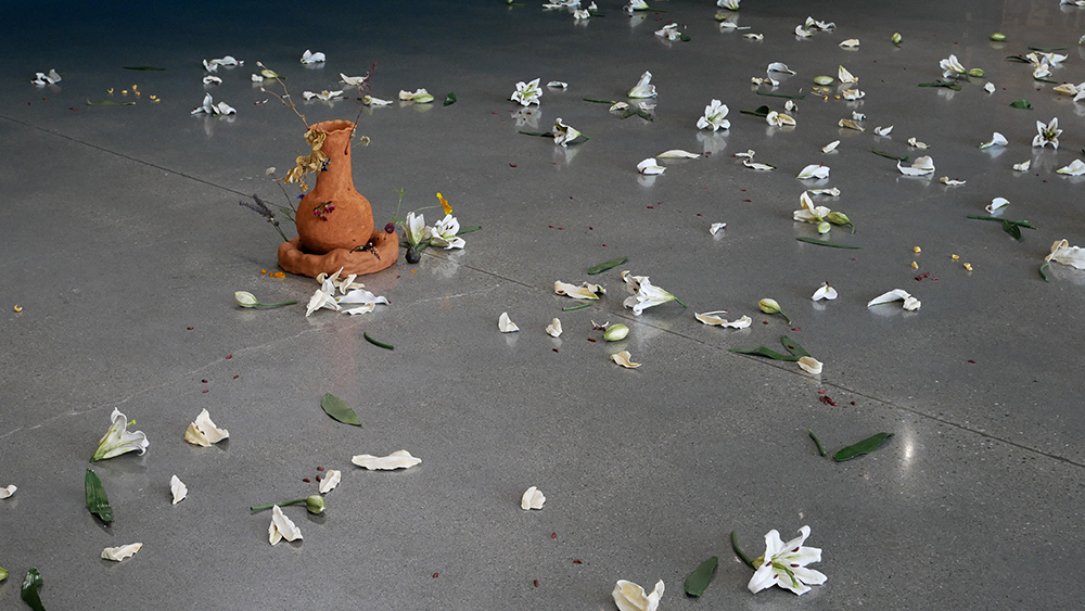 White cermaic flowers scattered on a concrete floor