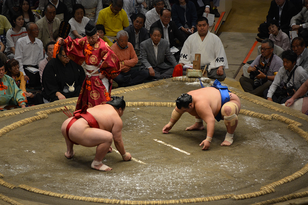 Two sumo wrestlers readying to do battle in the ring