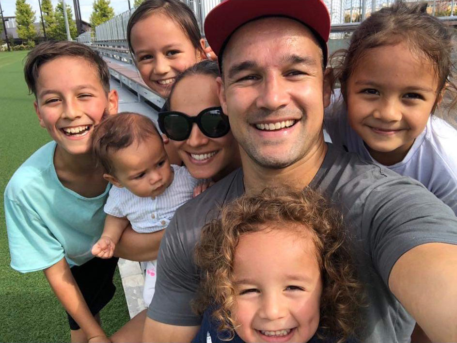 Tamati Ellison and his family taking a group selfie at a sportsground