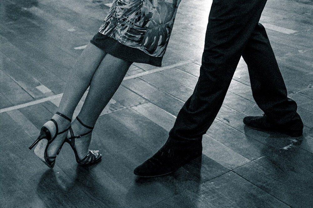 Two pairs of legs (a man's and a woman's) in mid-step on the dancefloor