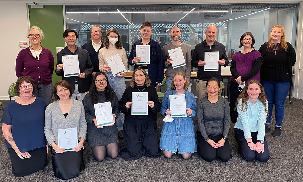 A group photo of Foundation staff holding up certificates for completing a te reo Maori  course