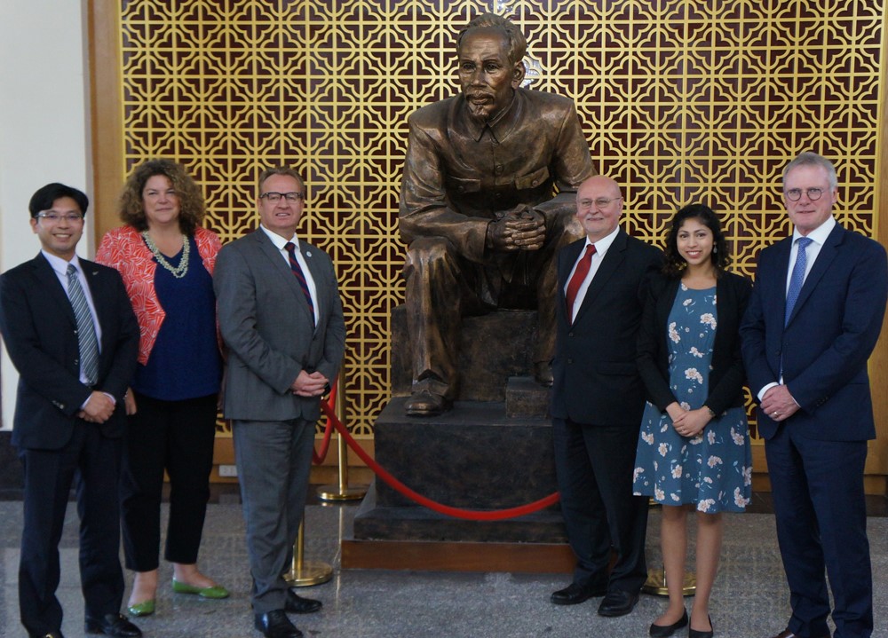 A group of people standing in front of a statue