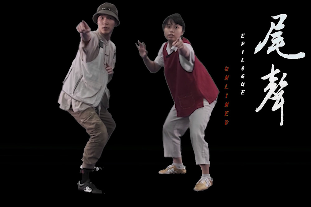 A screenshot showing two of the actors/dancers pointing at the camera