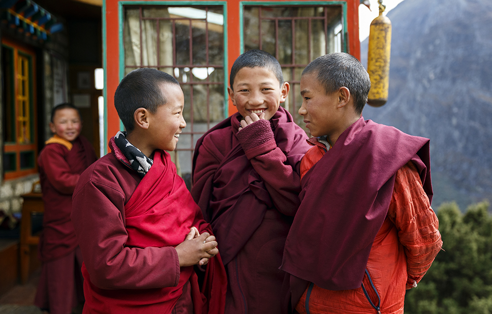 Three boys smiling boys in red robes