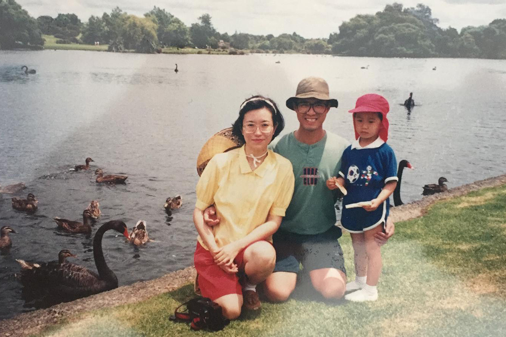 Wilson Chau as a young boy standing by a lake with his parents