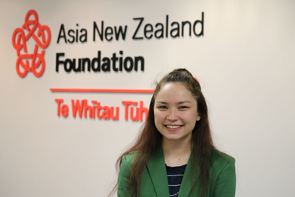 Francesa Zhang in front of the Asia New Zealand Foundation signage