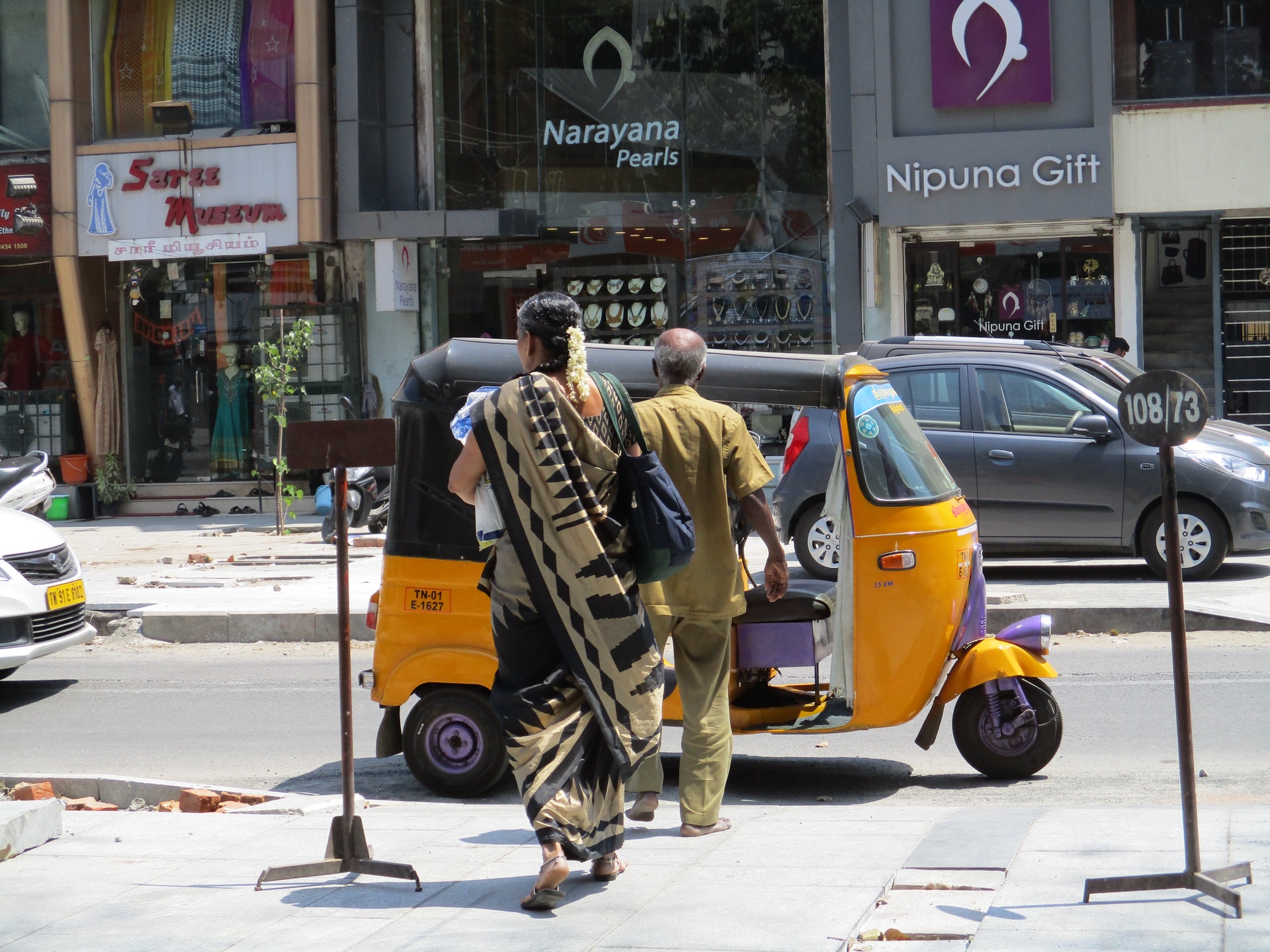 A man and a woman walking towards a tuktuk