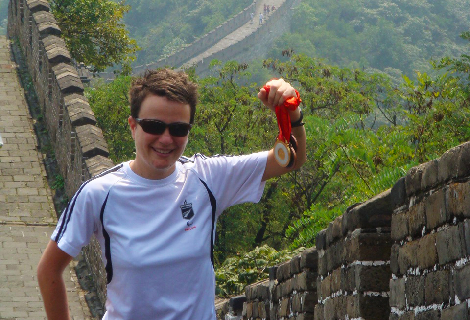 Paula standing on the Great Wall holding her medals