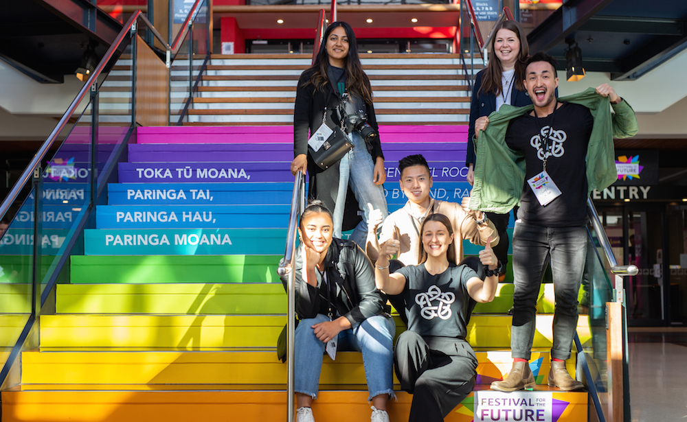 A group of Leadership Network members sitting on rainbow steps outside the festival venue