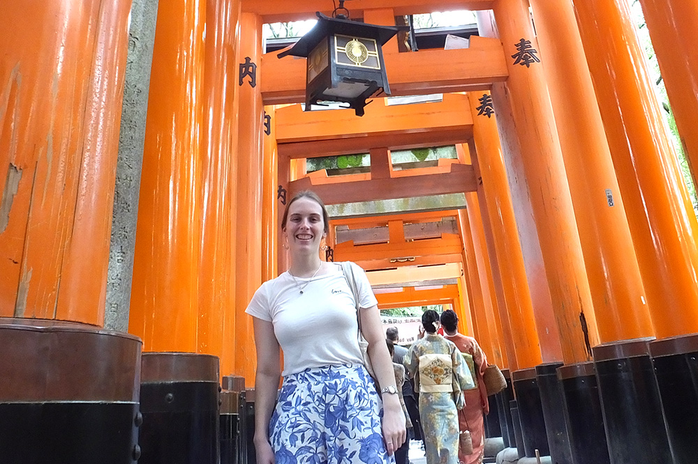 Leanne standing under the pillars of orange Japanese gates