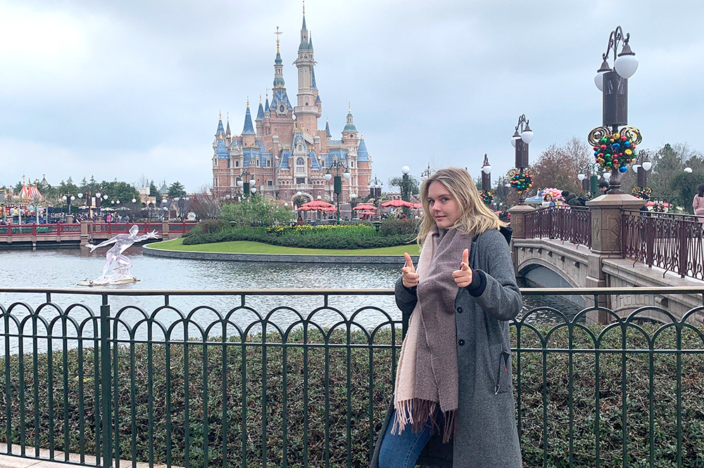 Megan standing in front of a castle at Shanghai Disney Resort