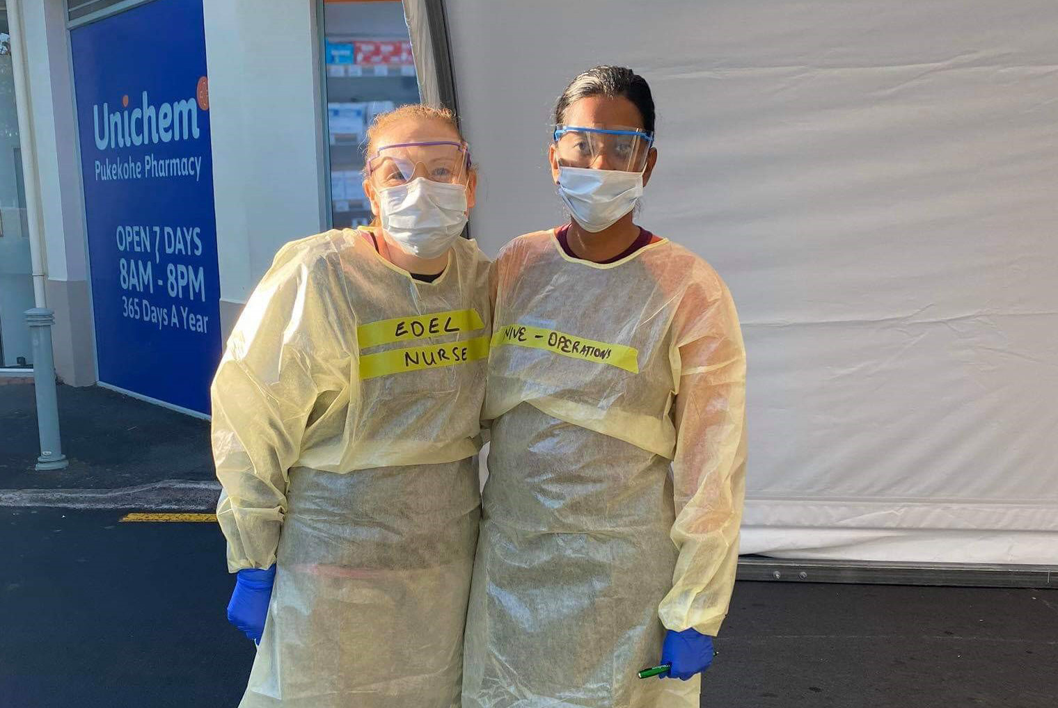 Nive and a colleague wearing gloves, masks and other protective clothing 