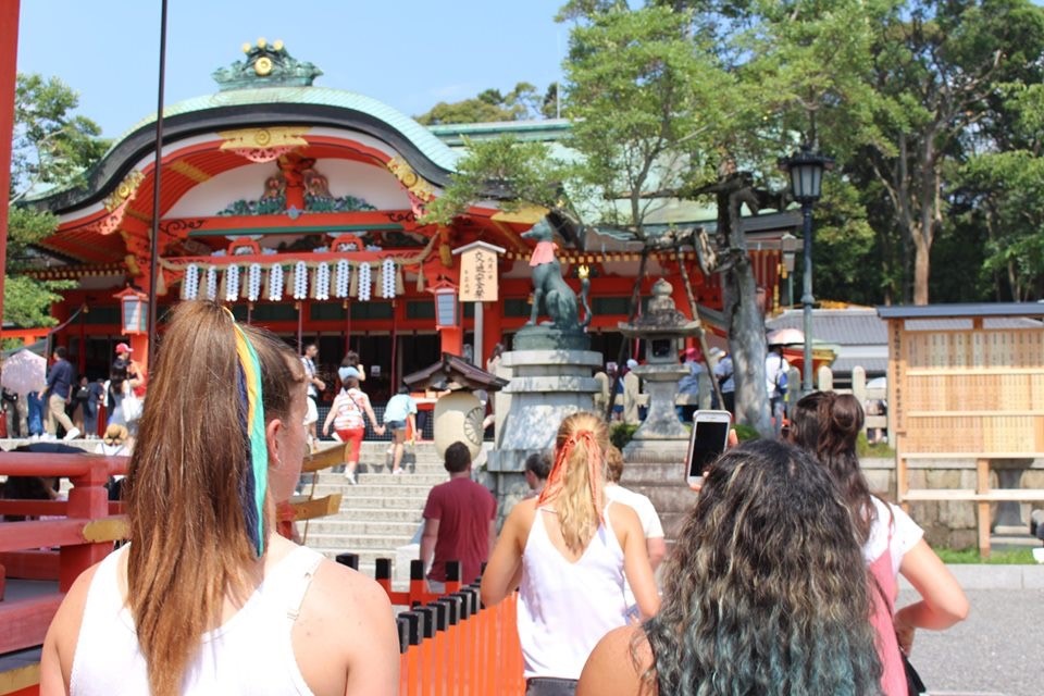 Members of the rowing team walking up to a shrine