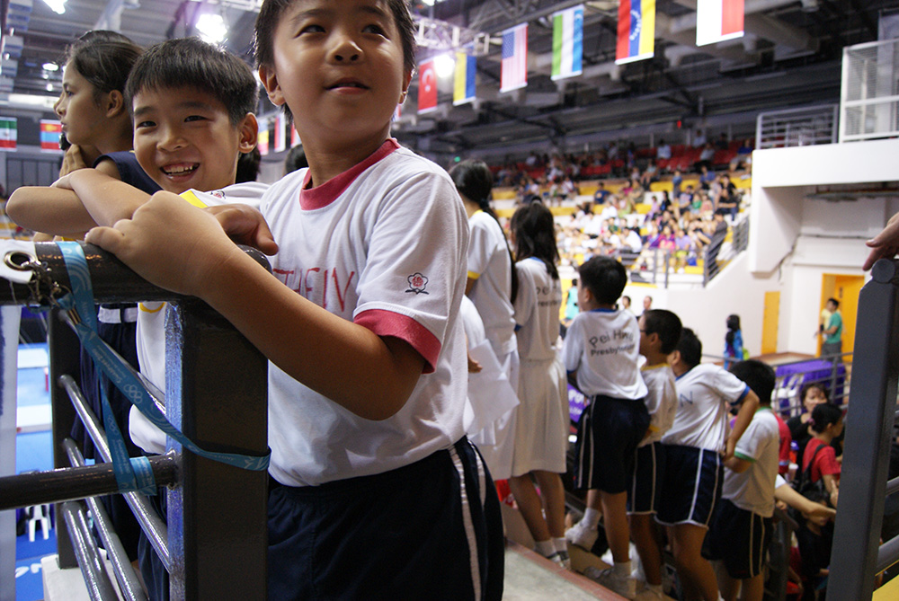 Two boys standing in the stands of a crowded arena