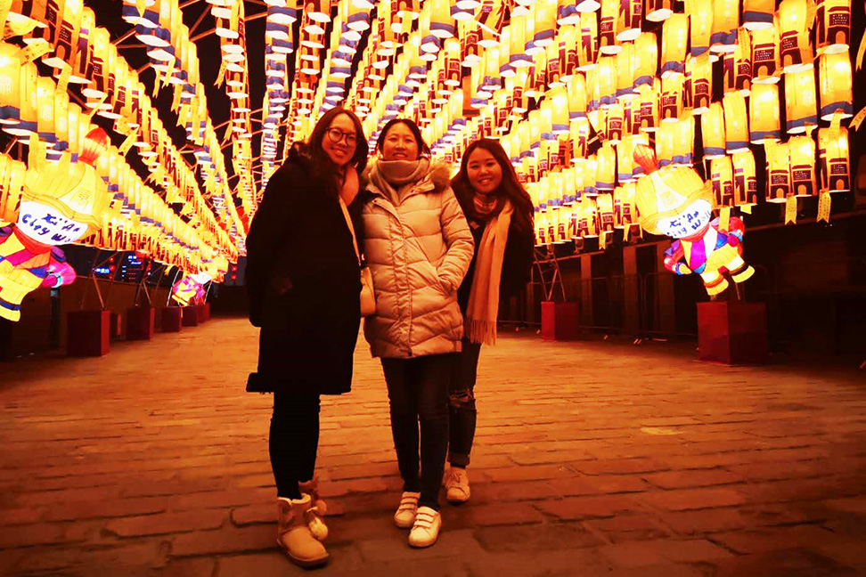 Tina with friends on a street adorned with lanterns